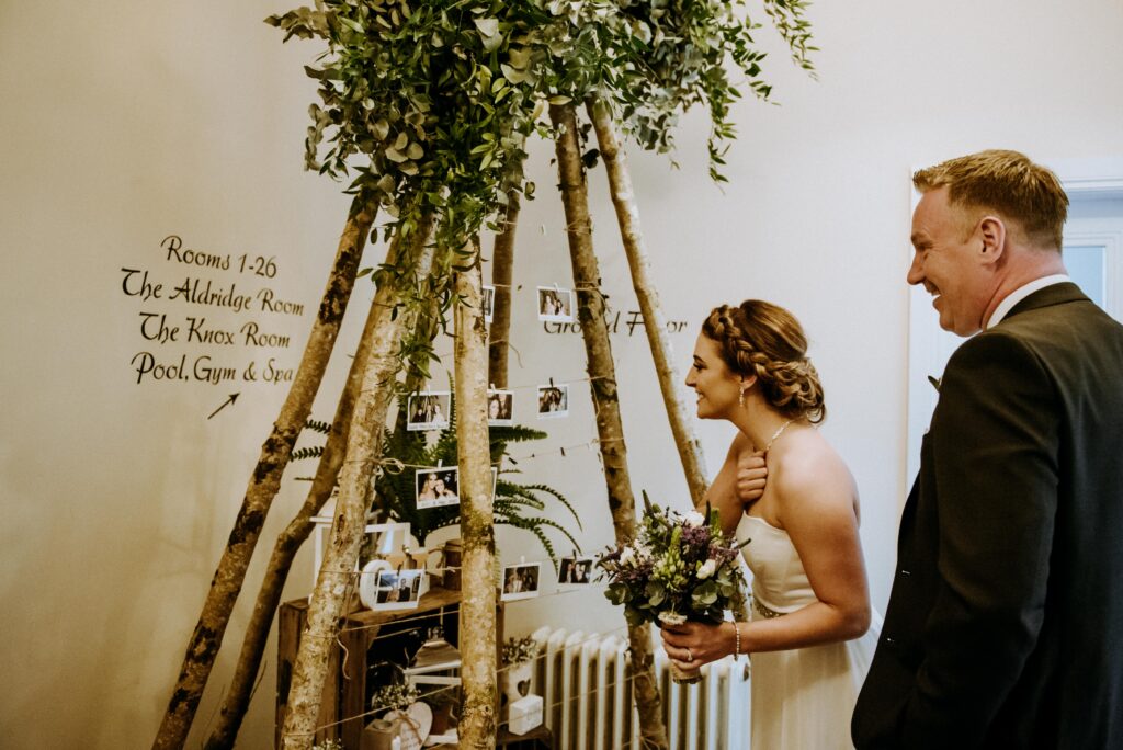 Married couple look at photo and floral display.