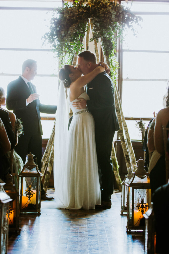 Married couple kiss at the top of church.